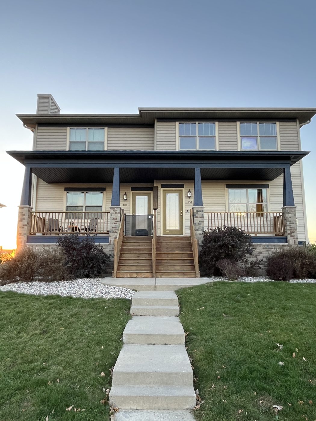 Two-story Meir Property Group duplex with a covered front porch, brick columns and a front lawn