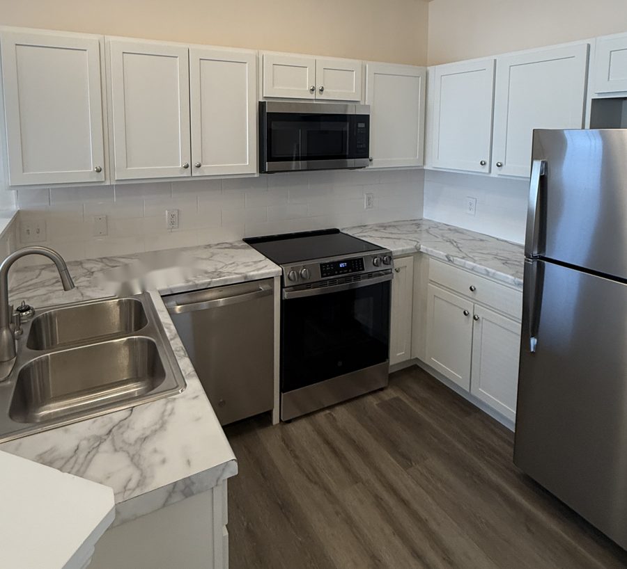 Updated kitchen with white shaker cabinets, marble-look counters and stainless steel appliances